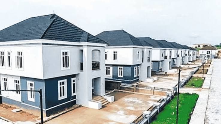 Full-floor penthouse living room with floor-to-ceiling windows over the Lagos lagoon at golden hour